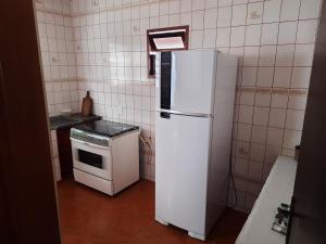 乌巴图巴Casa Ednalda的厨房配有白色冰箱和炉灶。
