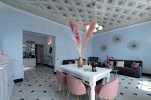 拉帕洛Casa Garibalda - seafronf apartment的客厅配有白色桌子和粉红色椅子