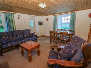 斯尼姆Gortagown Cottage的客厅配有蓝色的沙发和桌子