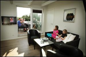 StenildVolstrup Apartments的一群人坐在客厅的沙发上