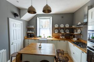 里士满DUNDAS COTTAGE - Beautiful Spacious 3 Bed Cottage in Richmond, North Yorkshire的厨房配有木桌和一些椅子