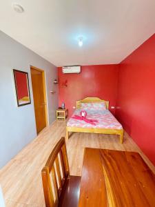 莫阿尔博阿Ananas Guesthouse的卧室配有红色墙壁内的一张床