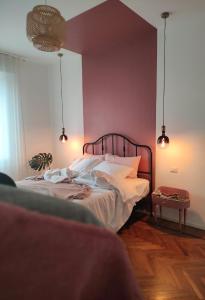 博洛尼亚Casa Tulù B&B的卧室配有一张带粉红色墙壁的大床