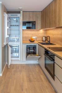 塔尔图Siili Apartment-free parking的带木制橱柜的厨房内的开放式冰箱