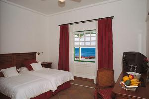 普拉亚布兰卡卡萨德尔额木巴加多酒店的一间卧室设有一张床和一个海景窗户