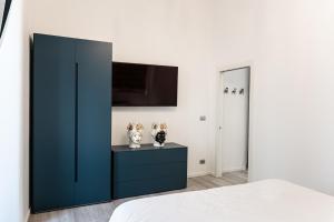 卡塔尼亚Il Moro Boutique Apartment的一间卧室配有蓝色橱柜和电视