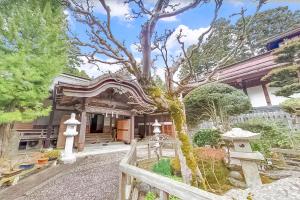 高野山高野山 宿坊 大明王院 -Koyasan Shukubo Daimyououin-的前面有一棵树的房子