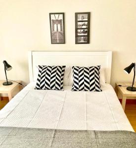 蓬塔德尔加达Yellow Five Apartment的一张带两个枕头和两盏灯的白色床