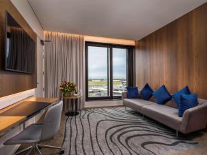 基督城克赖斯特彻奇机场诺富特酒店的带沙发和大窗户的客厅