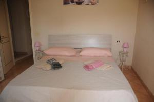 通法诺La Marinella的一张带毛巾和两盏粉红色灯的大型白色床