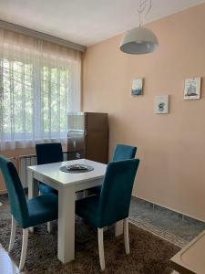库马诺沃City Place Apartments的一间配备有白色桌子和蓝色椅子的用餐室