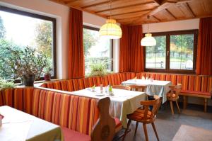 哈尔施塔特Pension Hirlatz的餐厅设有桌椅和窗户。