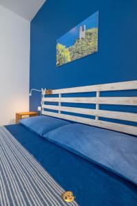 菲纳莱利古雷Pesce Palla Affittacamere的一间卧室设有一张蓝色墙壁的大床