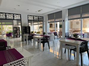 切什梅切什梅爱琴海郁金香酒店的用餐室设有桌椅和窗户。