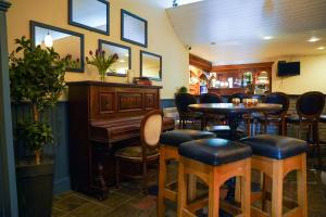 克利夫登欧科克及布朗酒店的酒吧设有钢琴、桌子和椅子