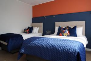 克利夫登欧科克及布朗酒店的蓝色和橙色墙壁的客房内的两张床