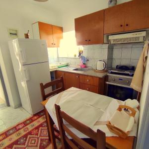 科帕罗Q Bay Apartments的厨房配有桌子和白色冰箱。