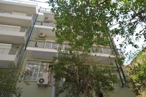 雅典阿尔比恩酒店的公寓大楼设有阳台和树木
