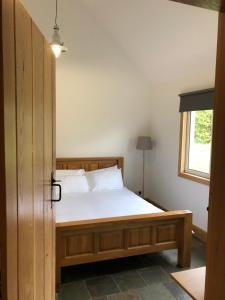 米尔盖The Cottage, near Glasgow Milngavie的一间卧室配有一张木框床和窗户。