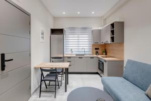 埃尔莫波利斯Argento urban apartments (cube)的一个带桌子和蓝色沙发的小厨房