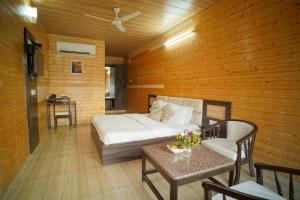 MādhopurComfort Inn Coral River的卧室配有一张床和一张桌子及椅子