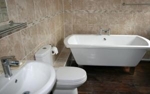 赖厄德Penralley House B&B的带浴缸、卫生间和盥洗盆的浴室