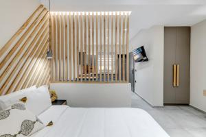 埃尔莫波利斯Argento urban apartment (sphere)的一间卧室设有一张床和一个大窗户