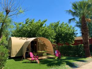 维亚斯Camping Club l'Air Marin的庭院内带桌椅的帐篷