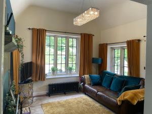 CressbrookThe Lodge的带沙发和2扇窗户的客厅