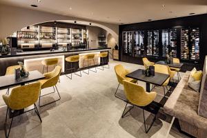 萨尔图西奥莎尔塔奥赛罗夫酒店的一间设有黄色桌椅的餐厅和一间酒吧