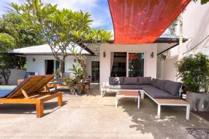 苏梅岛Pool Villa Bangrak, 2 mins to beach!!!!的一个带沙发和桌子的庭院和一座房子