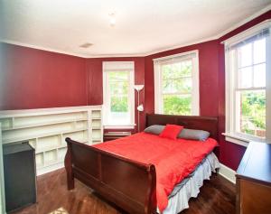 TuskegeeHistoric House on the Hill的红色卧室设有床和2扇窗户