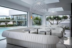 科斯镇钻石豪华酒店－仅限成年人的一间设有白色家具和大窗户的餐厅
