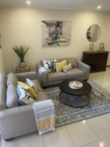 SandtonSunninghill Luxury Spacious Executive Penthouse的客厅配有两张沙发和一张桌子