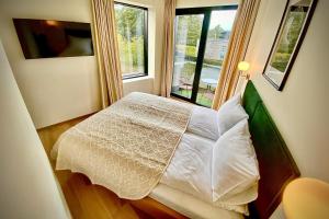 帕兰加SIRENA的卧室配有白色的床和窗户