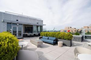 阿林顿Stylish Condo at Clarendon with Rooftop Views的庭院设有蓝色的沙发和桌椅