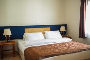 博德鲁姆Oya Butik Otel的一间卧室配有一张带蓝色床头板的床和两盏灯。