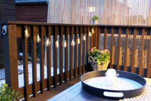 珀斯Luxurious Apartment with South facing Garden的甲板上的桌子,带灯光的栅栏