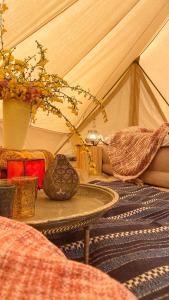 奥斯特坎普SENSI - 'FIRE' Restaurant and Glamping的带帐篷的房间,配有桌子和鲜花