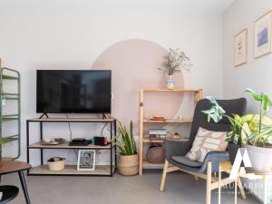 宏达瑞比亚La Muralla by Basquelidays的客厅配有平面电视和植物