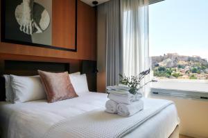 雅典Urban Frame Plaka的一间卧室配有带毛巾的床和窗户。