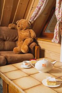 布科维纳-塔钱斯卡密斯家庭式旅馆的坐在桌子旁的椅子上的泰迪熊