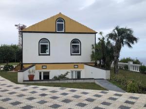 圣克鲁什达什弗洛里什A QUINTA DAS FLORES- Casa do Miradouro的白色的大房子,有黄色的屋顶