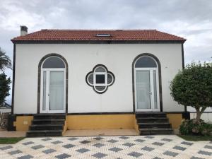 圣克鲁什达什弗洛里什A QUINTA DAS FLORES- Casa do Miradouro的白色的建筑,设有两扇窗户和屋顶