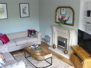 皮特洛赫里Woodburn ground-floor apartment in quiet setting in Pitlochry的客厅配有白色沙发和壁炉