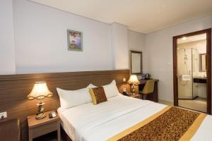 胡志明市Galaxy Airport Hotel的一间卧室设有一张大床和淋浴