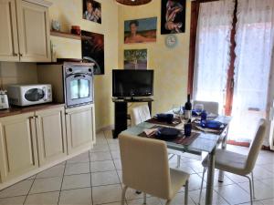 斯坎迪奇Casa di Giada appartamento luminoso a due passi dalla tramvia per Firenze的厨房配有桌椅和电视。