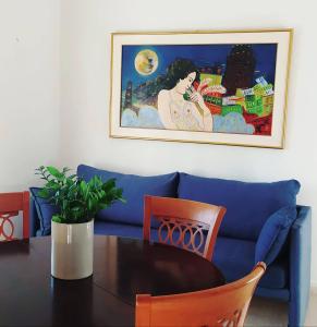 莱夫基米Alykes Family Resort的一张带桌子的蓝色沙发,墙上挂着一张照片