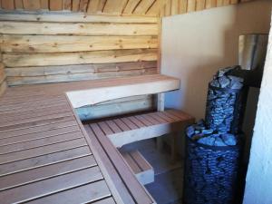 哈普萨卢Mõiskla saun ja puhkemaja的木制桑拿房,设有长凳和垃圾桶
