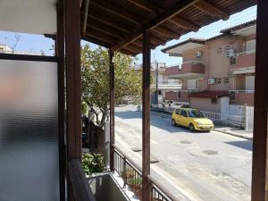 萨尔蒂House Anna Sarti的阳台享有黄色汽车的街道景色